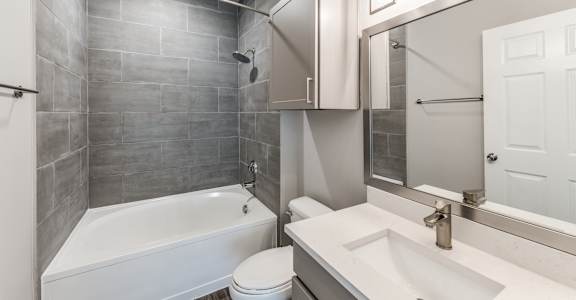 A bathroom with a white tub, sink, and toilet.