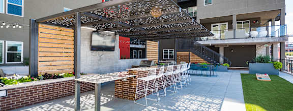 A patio with a table and chairs under a pergola.