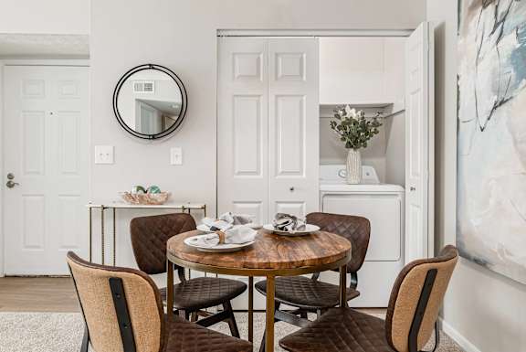 a dining room with a table and chairs and a mirror