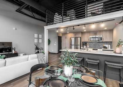 A modern dining area with a table set for two.at Raymond Block, Edmonton, T6E 3R7