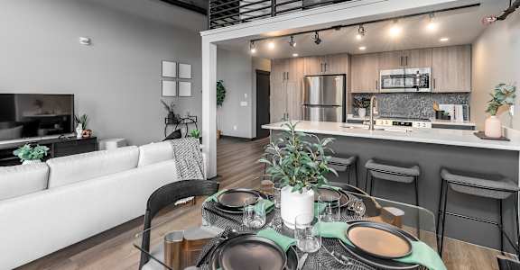 A modern dining area with a table set for two.at Raymond Block, Edmonton, T6E 3R7