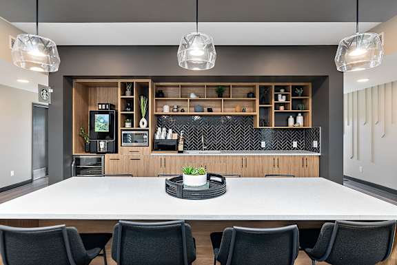 A modern kitchen with a long table and chairs.