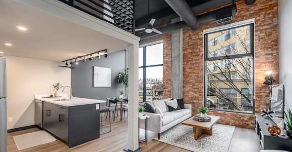 A modern kitchen with a refrigerator, sink, and a dining table with chairs.at Raymond Block, Edmonton, T6E 3R7