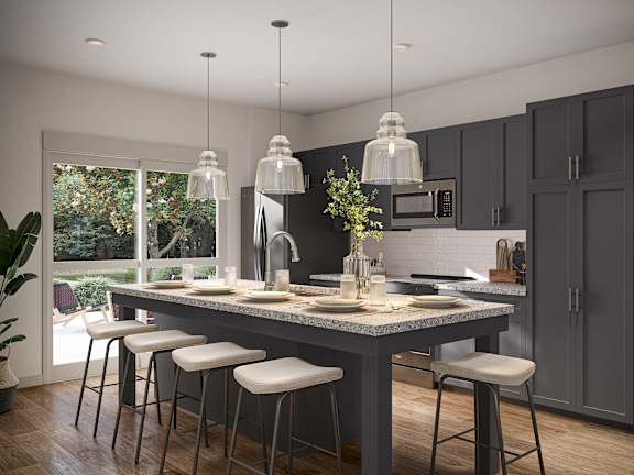 A modern kitchen with a large island and bar stools. at Allier Foley in Foley, AL
