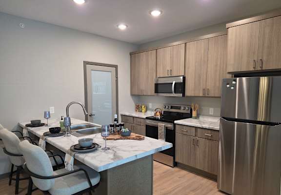 A modern kitchen with a dining table set for four.