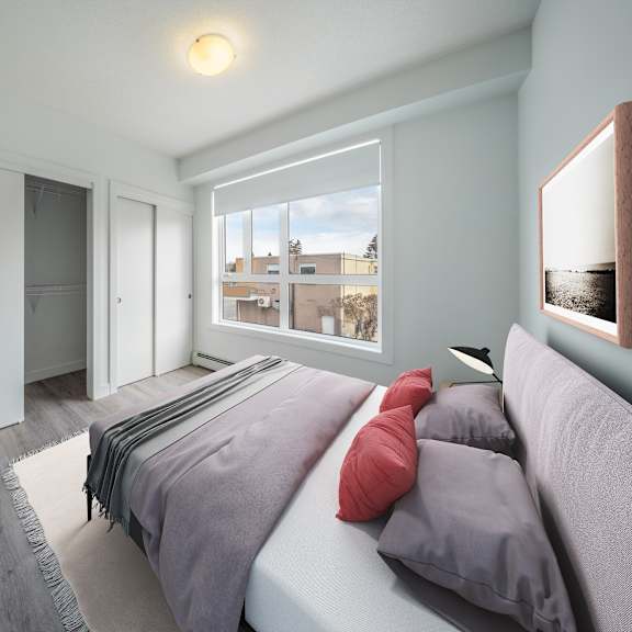 A bedroom with a bed, pillows, and a window overlooking a cityscape.