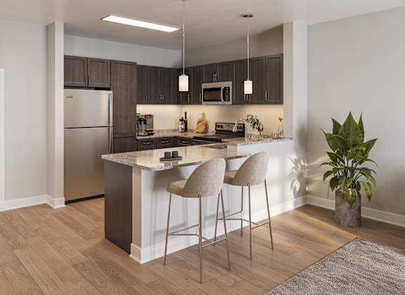 A kitchen with a bar area and two chairs. at Heritage Landing Apartments, Terre Haute, 47803
