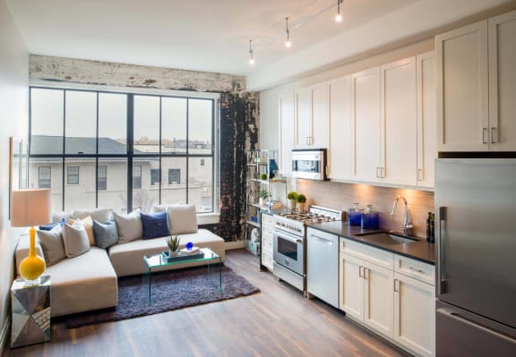 a living room with a kitchen and a large window