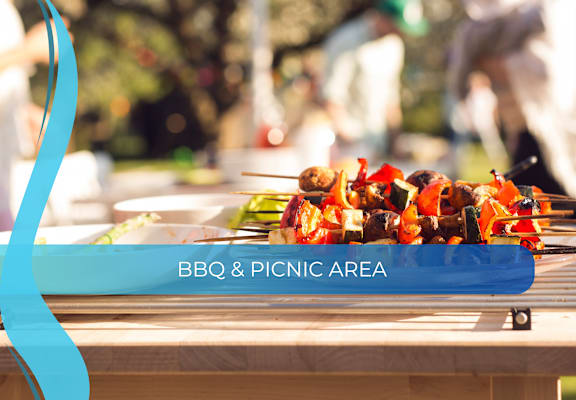 the bbq  picnic area sign on a picnic table with food on it