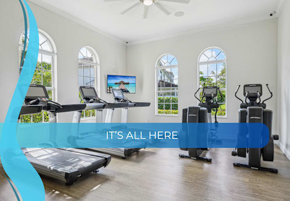 a gym with cardio machines and a banner that reads its all here