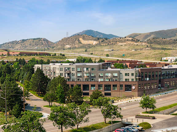 A view of a city with buildings, trees, and a mountain in the background.