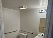 Thumbnail 7 of 7 - A white toilet with a white tank and a white door is in a bathroom.