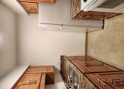 Thumbnail 4 of 15 - a kitchen with wooden cabinets and a stainless steel sink and a dryer