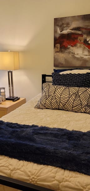 a bedroom with a bed and a painting on the wall