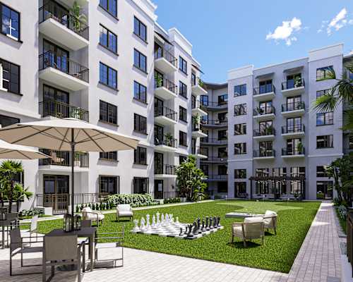 A large white apartment complex with a pool in the middle Leena Plantation Apartments in Plantation FL