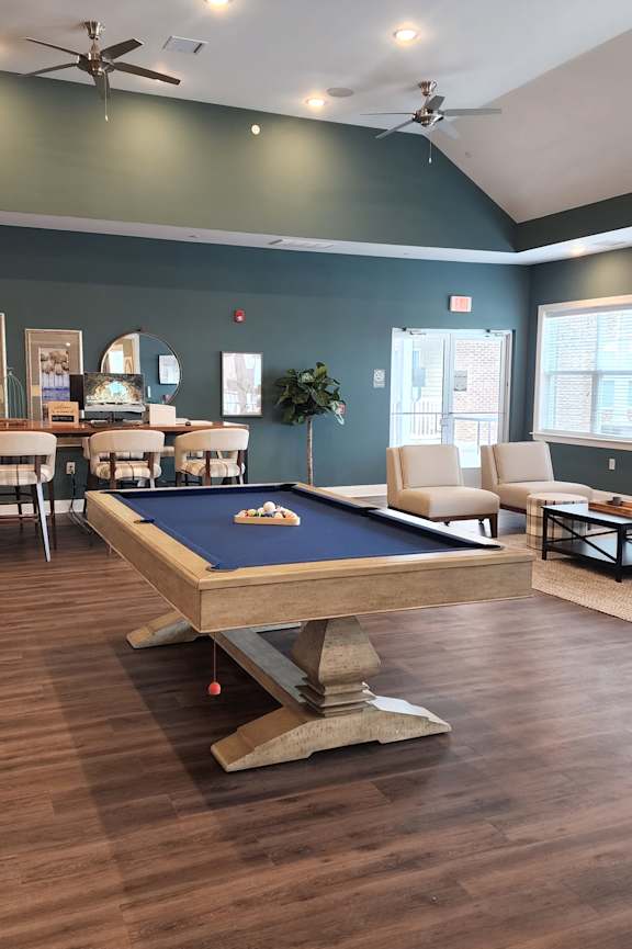 A pool table is in the middle of a room with a fireplace and a TV.