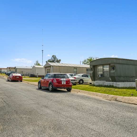 A red car is parked on the side of a street.