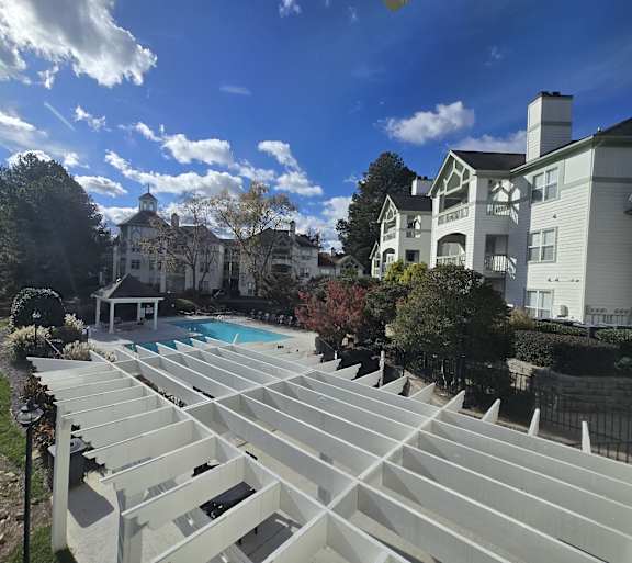 A large white building with a pool in front of it.