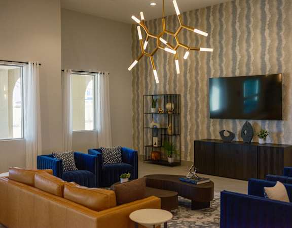 A modern living room with blue chairs and a wooden coffee table.