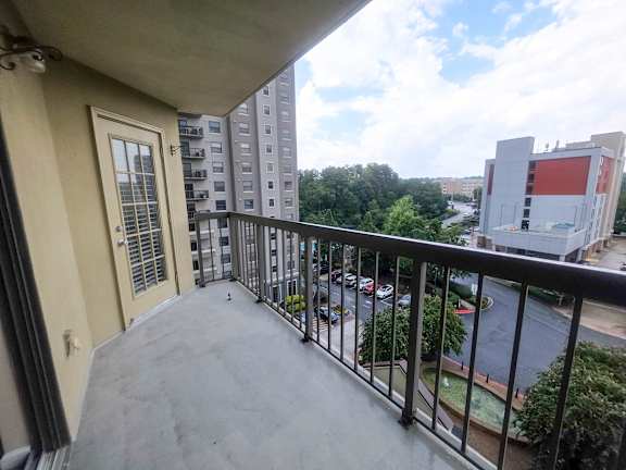 A balcony with a view of a street and buildings.
