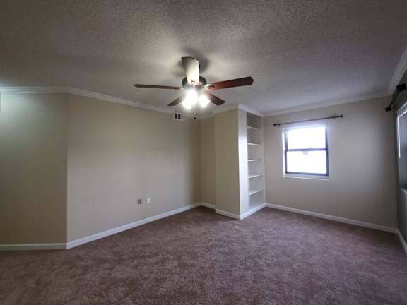 A room with a ceiling fan and a window.