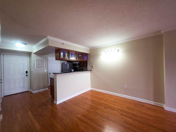 A kitchen area with a refrigerator, cabinets, and a countertop.