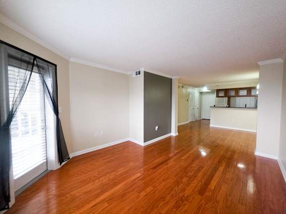 A room with wooden floors and a sliding glass door.