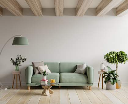 A living room with a green couch, a floor lamp, and a potted plant. at Siena Crossing Apartments, Apartments, Ankeny, IA