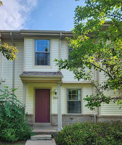 A house with a red door and a window with a curtain.