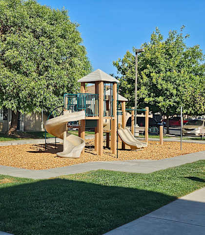 A playground with a wooden structure and a slide.