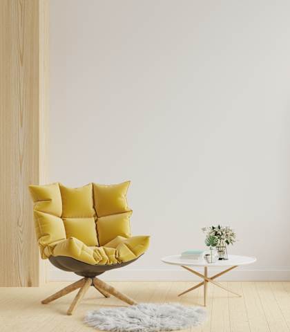 A yellow chair with a white table and potted plants in a room.