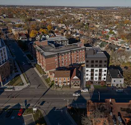 A view of a city from above with buildings, cars, and trees.