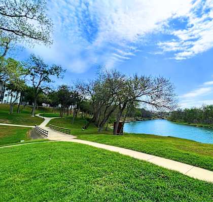 a path through a park with a river in the background