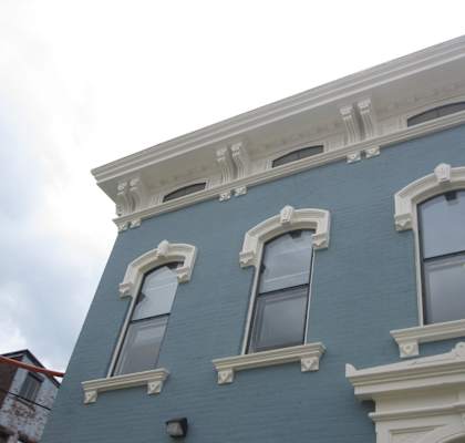 the side of a blue building with three windows
