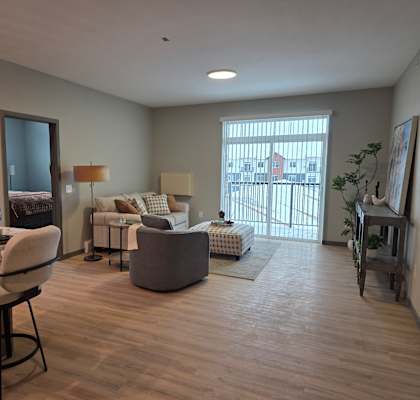 A well-lit living room with a dining table and chairs.