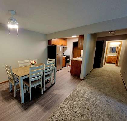 a dining room with a table and chairs and a kitchen