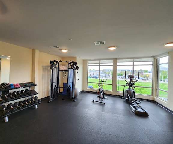 A gym with a variety of equipment including weights, a treadmill, and a stationary bike.