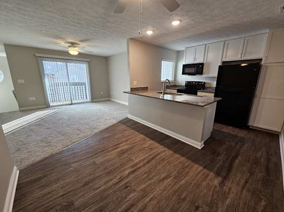 an empty kitchen and living room with a large window