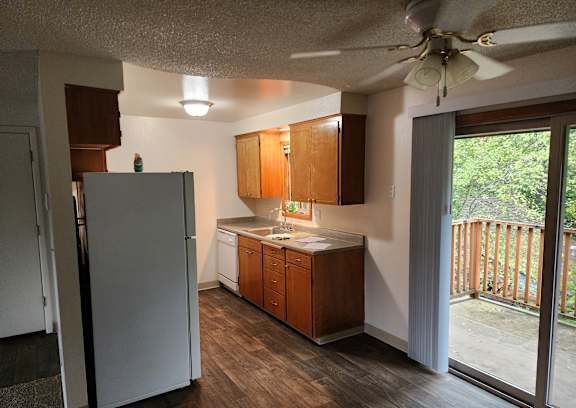 an empty living room with a hallway to a closet and a door to a room
