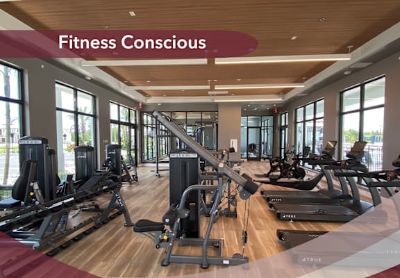 a gym with cardio equipment and a fitness conscious sign on the ceiling
