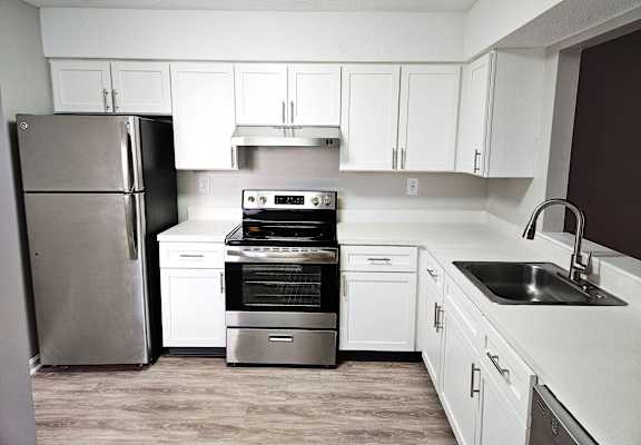 A kitchen with white cabinets and appliances.
