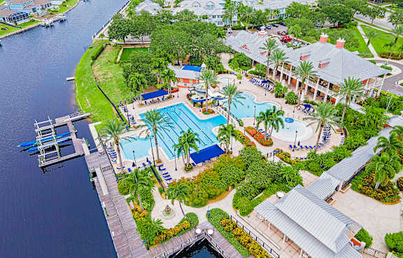 An aerial view of a resort with a pool and palm trees.
