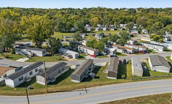 A road runs through a residential area with houses on both sides.