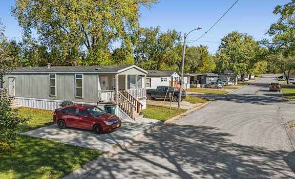 A red car is parked in front of a house.