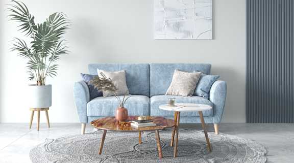 A living room with a blue couch, a wooden coffee table, and a potted plant.