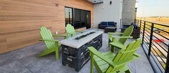 a patio with a fire pit and green chairs at Upscale Living at the Grand off 45th, Fargo, 58104