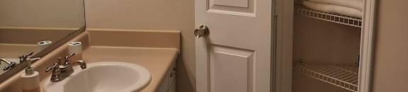 a small bathroom with white cabinets and a built in shower