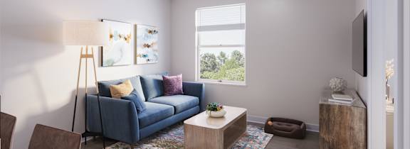 A living room with a blue couch, a wooden coffee table, and a television.