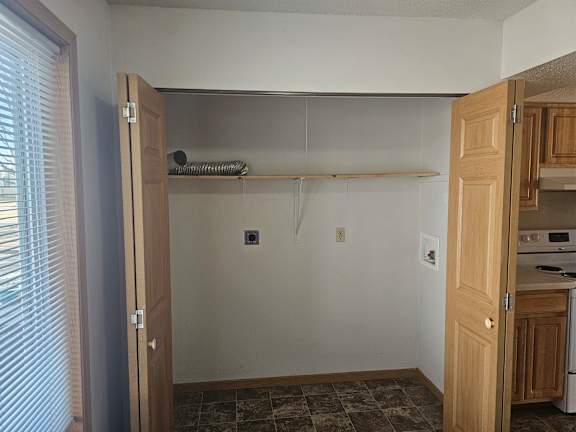 A kitchen with a white wall and a wooden door.