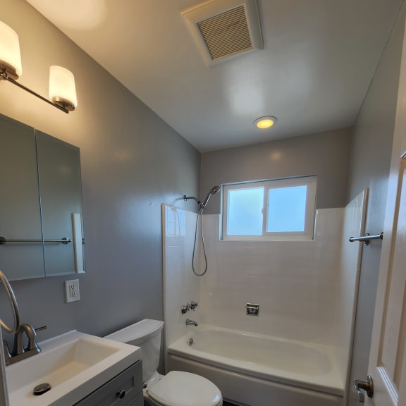 a bathroom with a toilet and a sink and a window